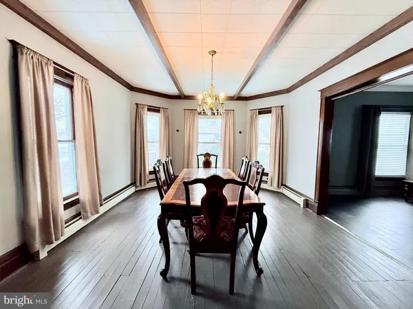a view of a a dining room with furniture window and wooden floor