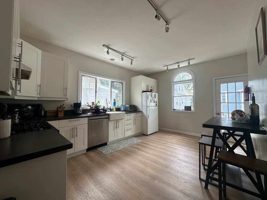 62 Bromfield Road, Unit 2 Somerville, MA 02144 - Photo 5 of 14 a kitchen with sink cabinets and dining table chair