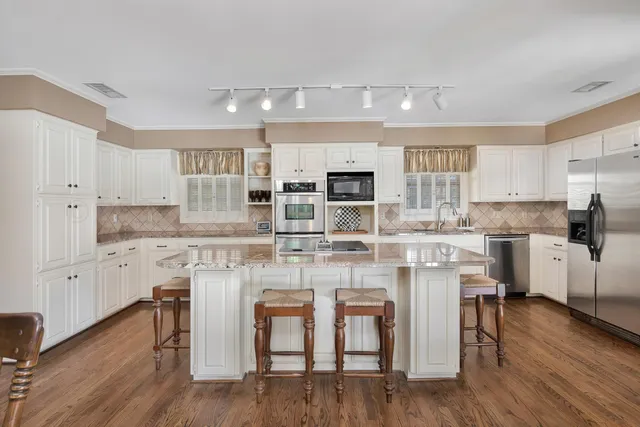 a kitchen with stainless steel appliances granite countertop a stove refrigerator and cabinets