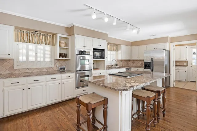a kitchen with granite countertop white cabinets and white appliances