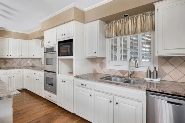 a kitchen with sink stove and wooden floor