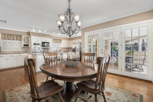 a view of a dining room with furniture wooden floor and chandelier