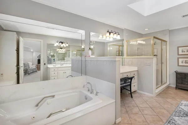 a spacious bedroom with a bed a table and large windows