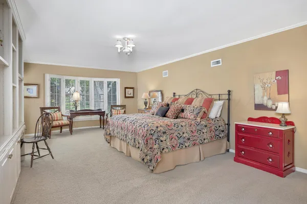 a spacious bedroom with a bed and a chandelier