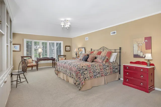 a spacious bedroom with a bed and a chandelier