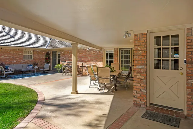 a backyard of a house with barbeque oven table and chairs