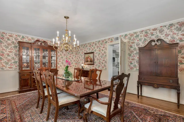 a dining room with furniture a chandelier and wooden floor
