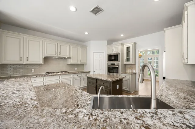 a kitchen with stainless steel appliances granite countertop a sink stove and refrigerator