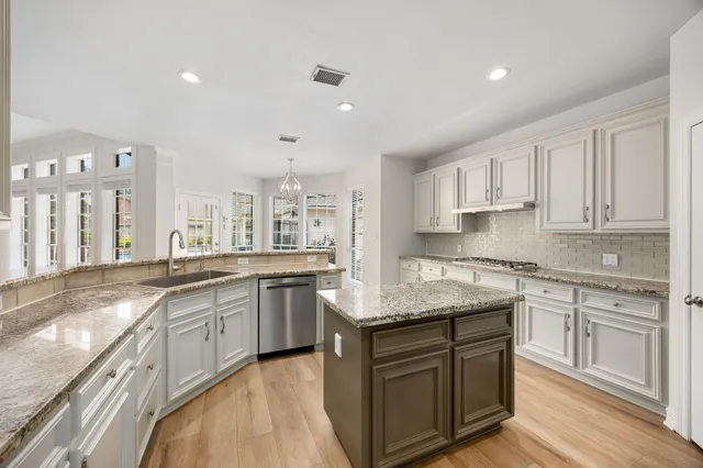 a kitchen with granite countertop sink stove and cabinets