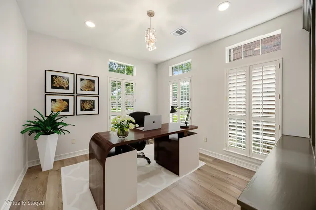 a dining room with wooden floor and windows
