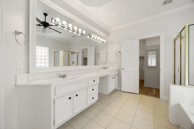 a spacious bathroom with a double vanity sink a mirror and a shower
