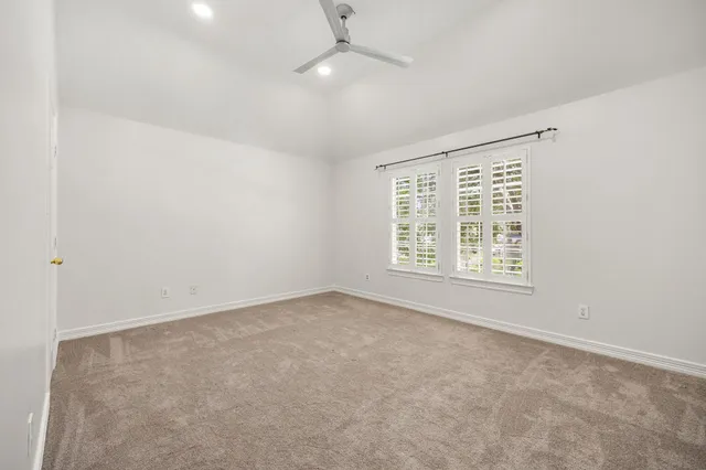 an empty room with a window and a ceiling fan