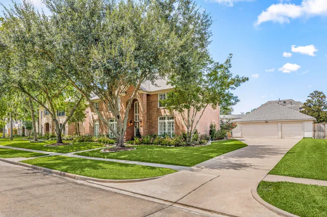 a front view of a house with a yard and trees