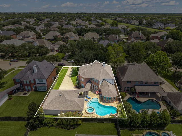 an aerial view of residential houses with outdoor space and swimming pool