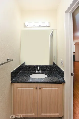 a bathroom with a granite countertop sink and a mirror