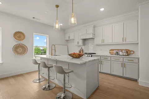 a kitchen with granite countertop a table chairs stove and cabinets