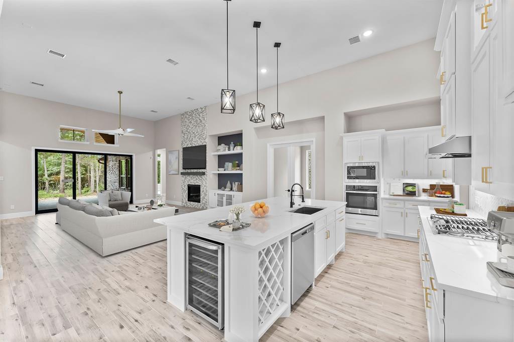a large white kitchen with stainless steel appliances kitchen island granite countertop a stove and more cabinets
