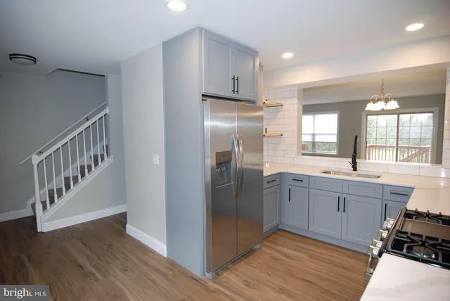 a kitchen with stainless steel appliances granite countertop a refrigerator a stove and a sink