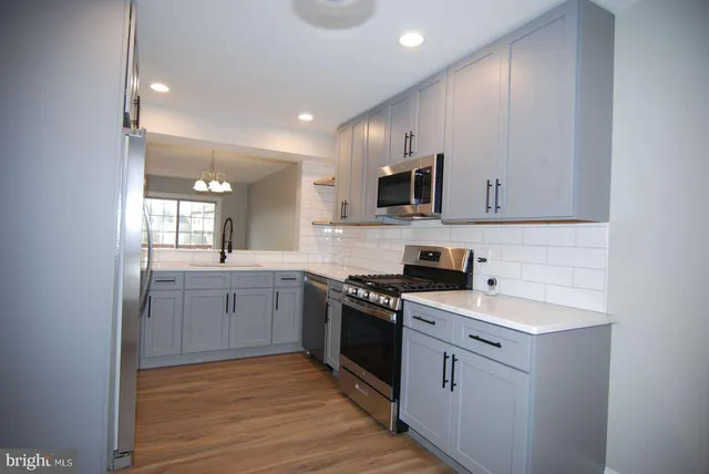 a kitchen with a sink cabinets and wooden floor