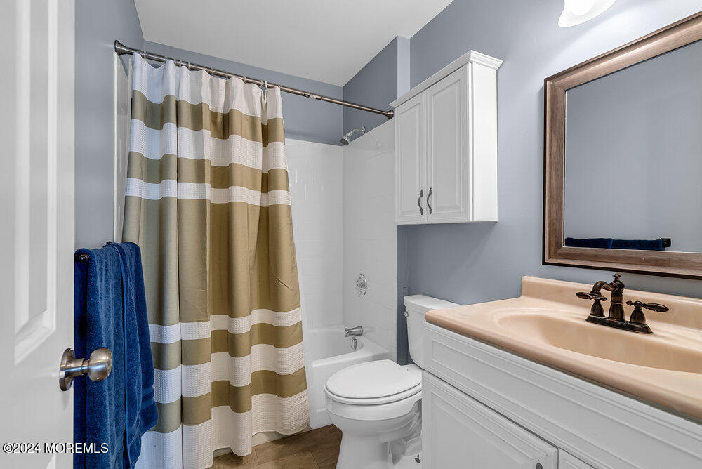 92 Concord Circle Howell, NJ 07731 - Photo 17 of 23 a bathroom with a sink a toilet a mirror and shower curtain