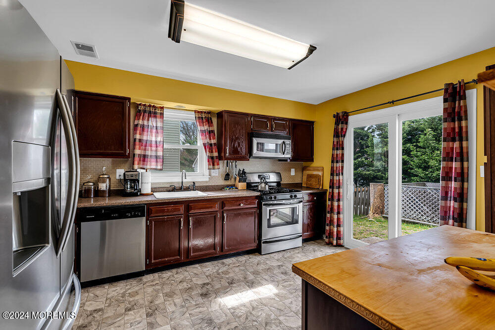 92 Concord Circle Howell, NJ 07731 - Photo 8 of 23 a kitchen with stainless steel appliances granite countertop sink stove and refrigerator