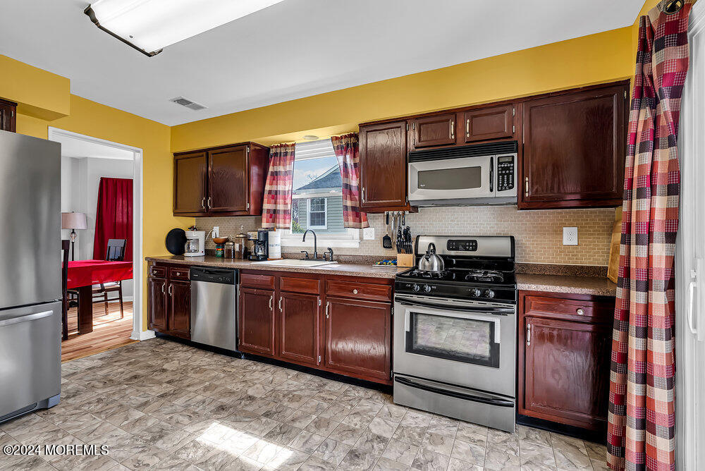 92 Concord Circle Howell, NJ 07731 - Photo 9 of 23 a kitchen with stainless steel appliances granite countertop a stove top oven a sink and dishwasher