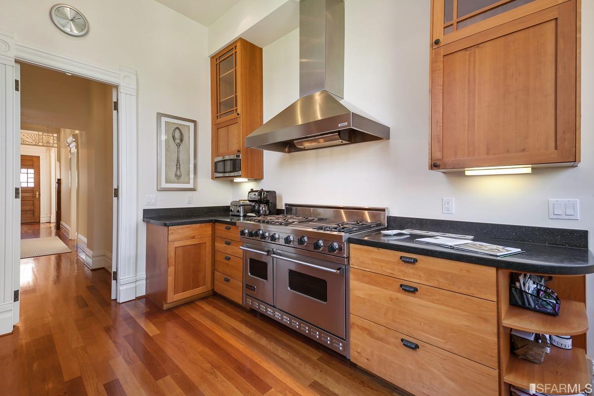 Frederick Street San Francisco, CA 94117 - Photo 18 of 61 a kitchen with stainless steel appliances a stove and white cabinets with wooden floor