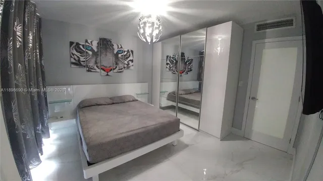 a spacious bedroom with a bed and a chandelier