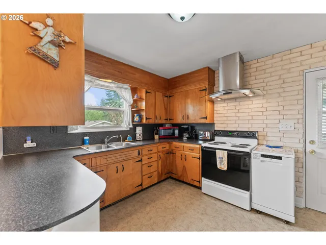 a kitchen with stainless steel appliances granite countertop a sink a stove and a refrigerator