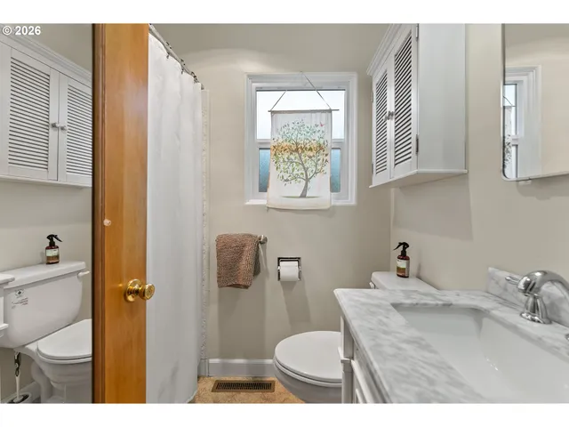 a bathroom with a granite countertop sink toilet and a mirror