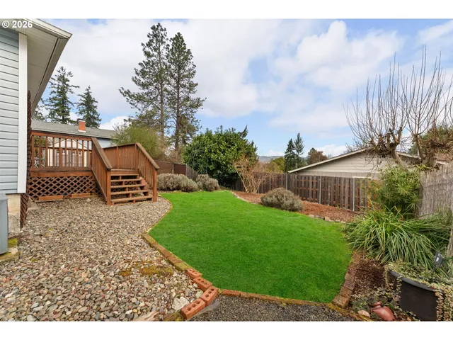 a view of a backyard with wooden fence