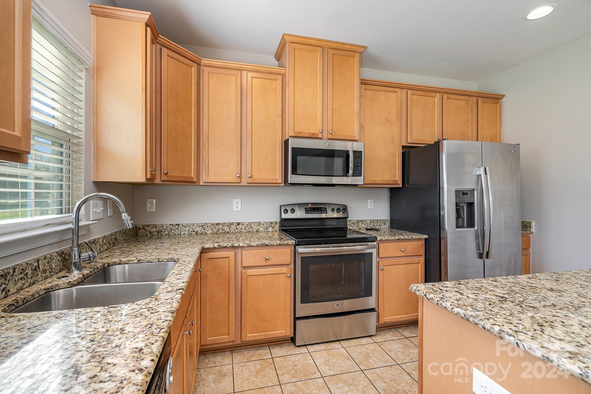 2005 Clover Hill Road Indian Trail, NC 28079 - Photo 7 of 19 a kitchen with stainless steel appliances granite countertop a sink stove and refrigerator