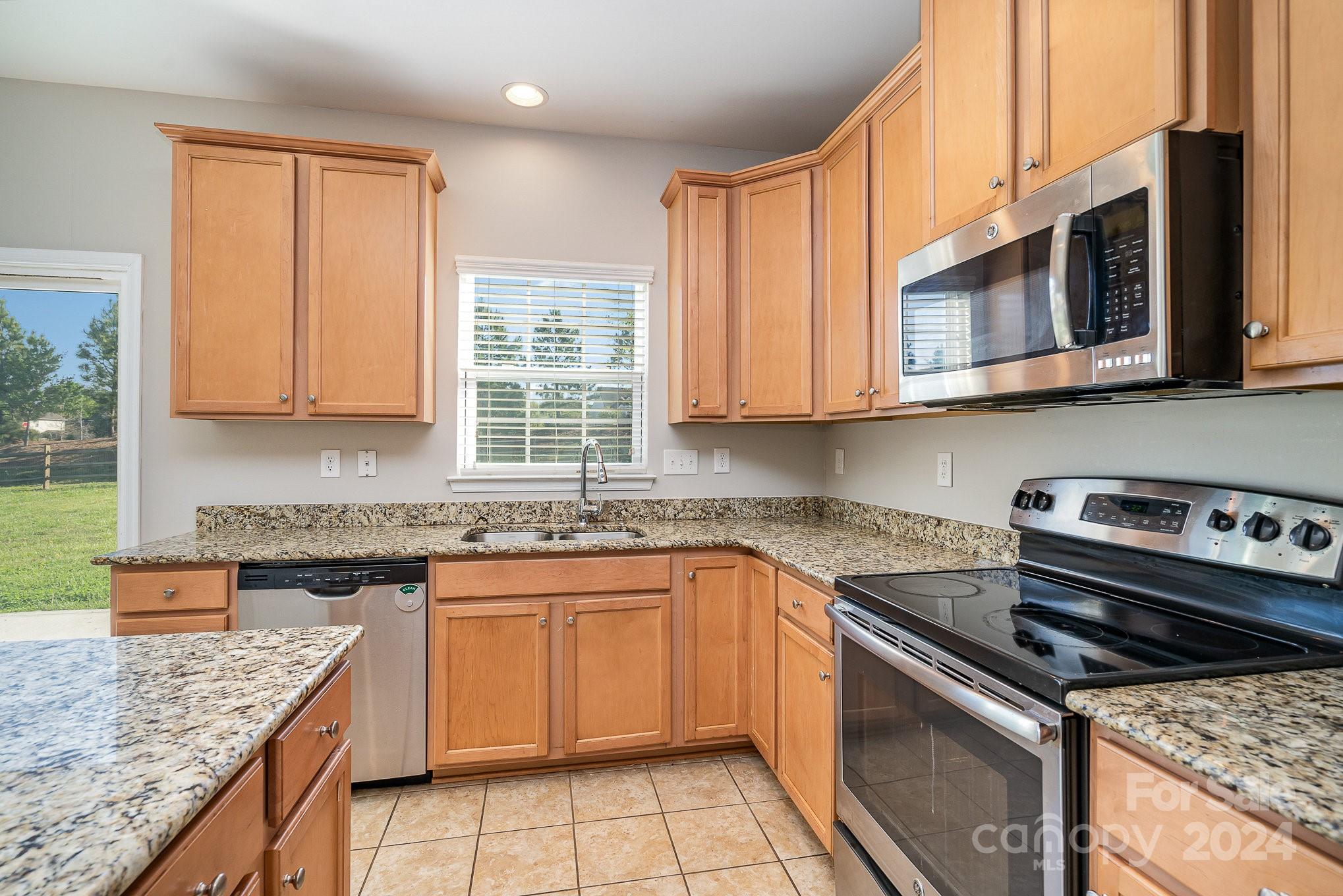 2005 Clover Hill Road Indian Trail, NC 28079 - Photo 8 of 19 a kitchen with stainless steel appliances granite countertop a stove a sink and a microwave