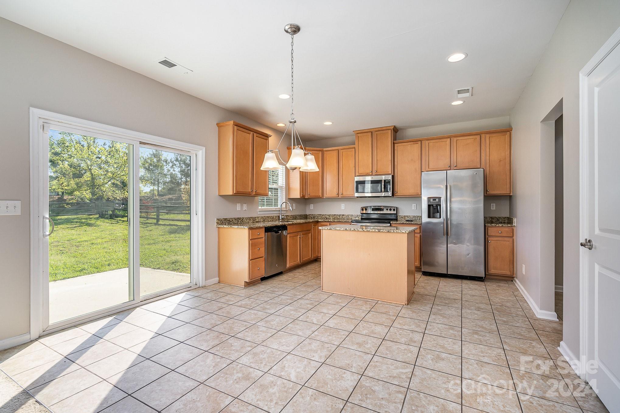 2005 Clover Hill Road Indian Trail, NC 28079 - Photo 9 of 19 a kitchen with stainless steel appliances granite countertop a stove a sink dishwasher a refrigerator with white cabinets and wooden floor