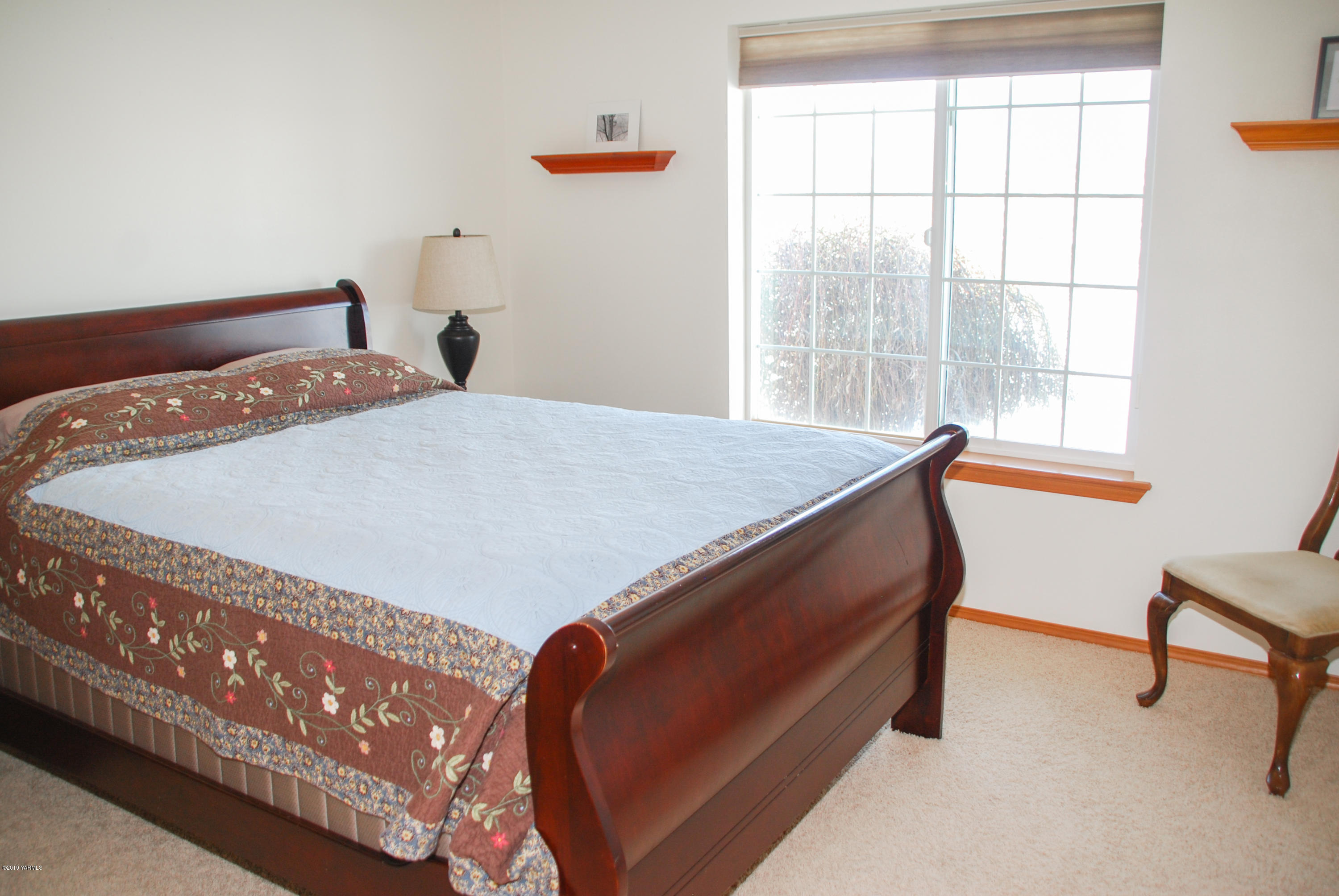 1271 North Granger Road Zillah, WA 98953 - Photo 20 of 30 a bed sitting in a bedroom next to a window