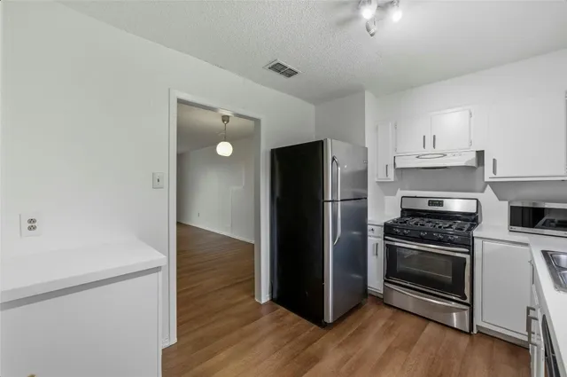 a kitchen with a refrigerator and a stove top oven