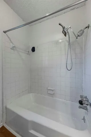 a bathroom with a bath tub with a shower