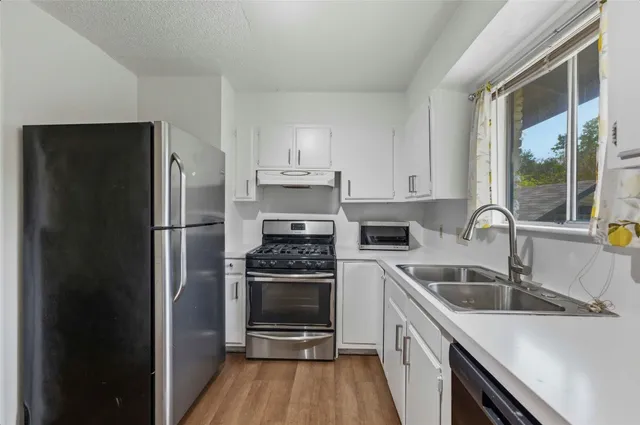a kitchen with a refrigerator stove and sink