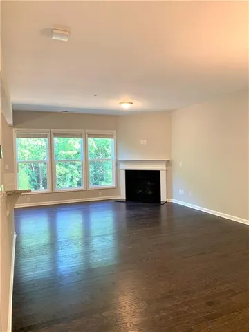 an empty room with large windows and a fireplace
