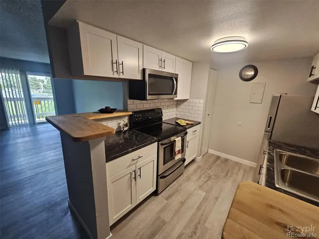 a kitchen with granite countertop a stove and a microwave