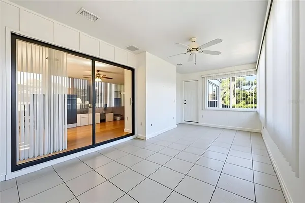 an empty room with a window and a fan