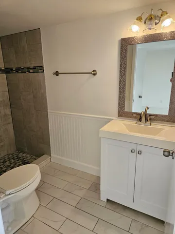 a bathroom with a sink a toilet and shower