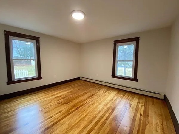 46 Sutton Road, Unit A Millbury, MA 01527 - Photo 11 of 14 a view of an empty room with wooden floor and a window
