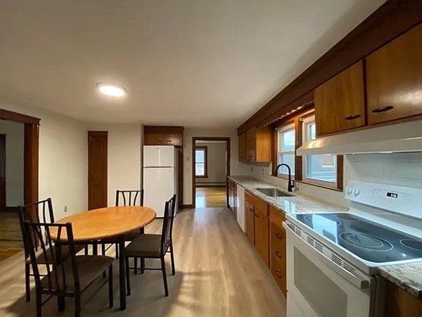 46 Sutton Road, Unit A Millbury, MA 01527 - Photo 6 of 14 a kitchen with a table chairs stove and cabinets
