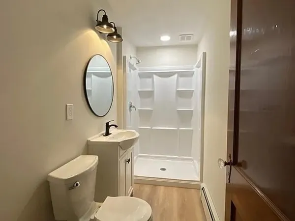a bathroom with a sink mirror toilet and shower
