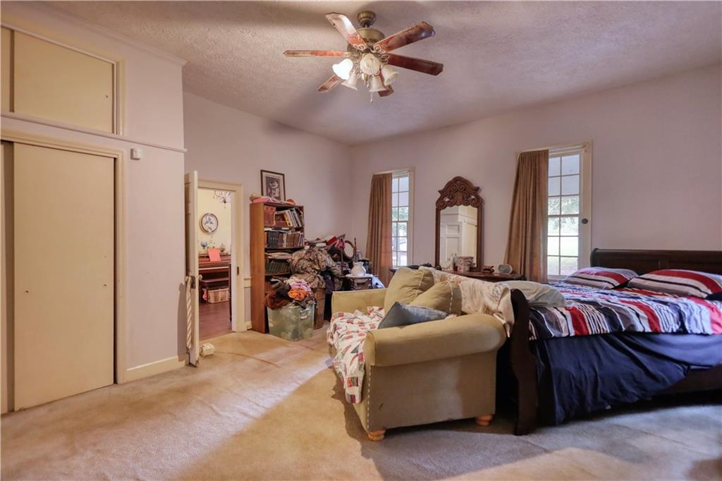 5011 Penfield Road Union Point, GA 30669 - Photo 16 of 68 a bedroom with bed and a chandelier