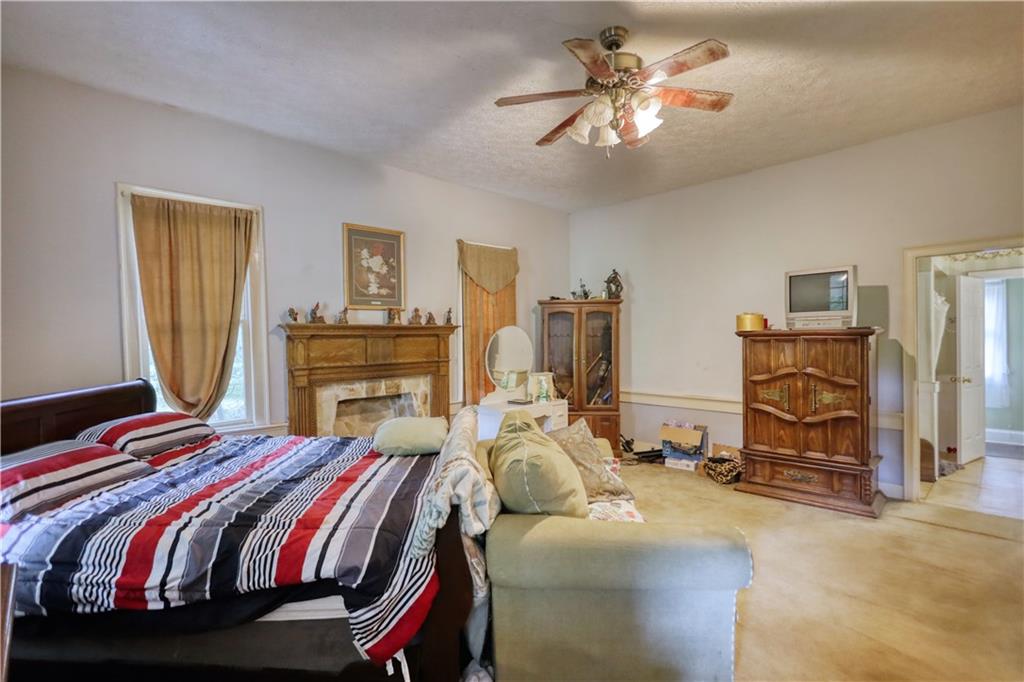 5011 Penfield Road Union Point, GA 30669 - Photo 17 of 68 a bedroom with a bed and a chandelier