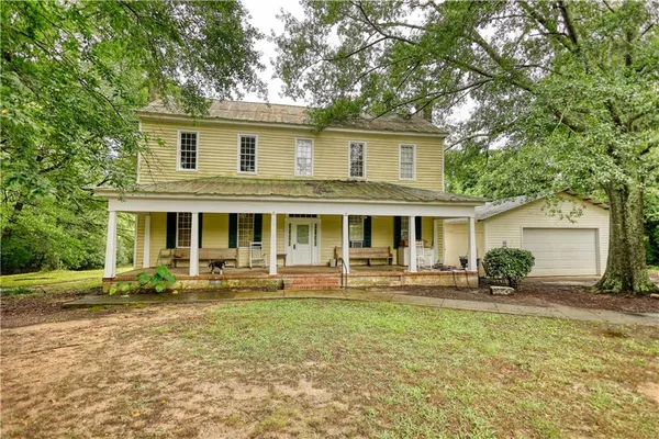 a front view of house with yard and trees in the background