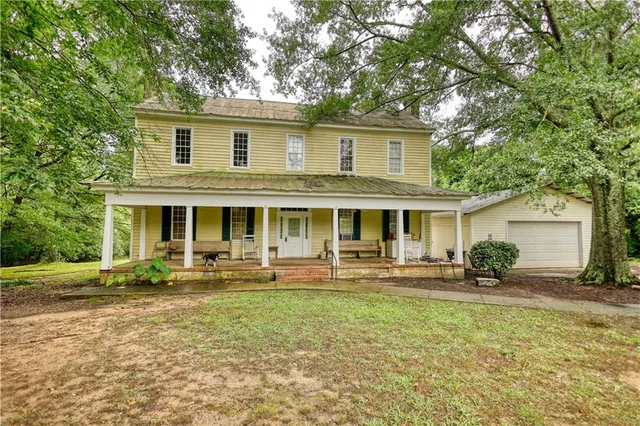 a front view of house with yard and trees in the background