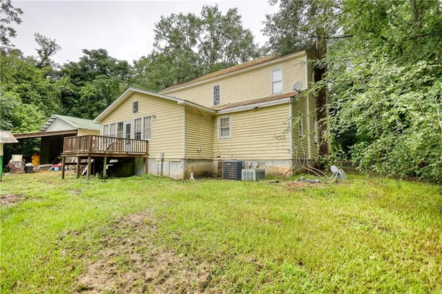 an aerial view of a house with a yard and large trees